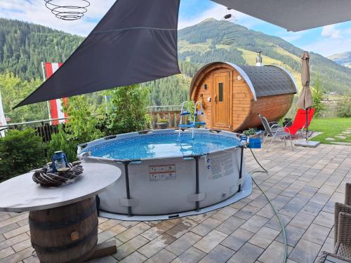 a hot tub on a patio next to a cabin at Landhaus Oberzinnegg in Saalbach Hinterglemm