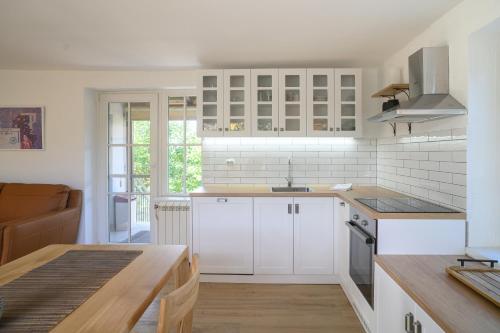 a kitchen with white cabinets and a wooden table at Kings Hill - Familly Retreat in Sremski Karlovci