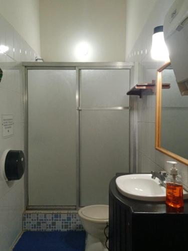 a bathroom with a shower and a toilet and a sink at Hotel El Recreo Lanquín-Champey in Lanquín