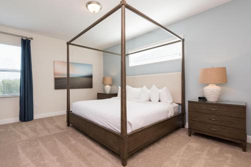 a bedroom with a canopy bed with white pillows at Lovely Home With Private Pool And Air Hockey Table Near Disney With Waterpark & Resort Access At Encore Resort - 7467Mr in Kissimmee