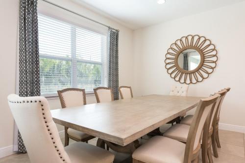 a dining room table with chairs and a mirror at Lovely Home With Private Pool And Air Hockey Table Near Disney With Waterpark & Resort Access At Encore Resort - 7467Mr in Kissimmee