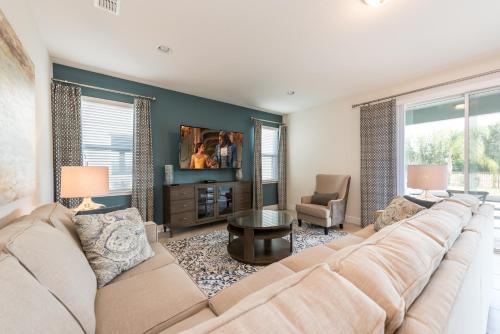 a living room with a large couch and a table at Lovely Home With Private Pool And Air Hockey Table Near Disney With Waterpark & Resort Access At Encore Resort - 7467Mr in Kissimmee