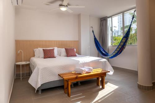 a bedroom with a bed with a table and a window at New Pueblito Suites - Cerca a la Playa in Cartagena de Indias