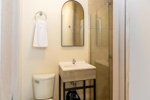 a bathroom with a toilet and a sink and a shower at New Pueblito Suites - Cerca a la Playa in Cartagena de Indias