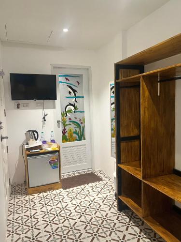 a room with a tv on the wall and a floor at Yok Guesthouse Jomtien in Jomtien Beach