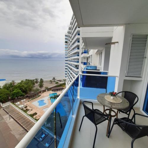 a balcony with a table and chairs and the ocean at Reserva Del Mar Apartamentos in Gaira