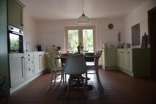 a kitchen with a table and chairs in it at The Hive, Maghera, Newcastle in Maghera
