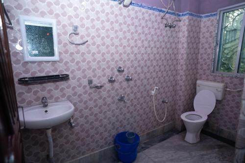 a bathroom with a sink and a toilet at Binay chapa homestay in jaldapara in Mādāri Hāt
