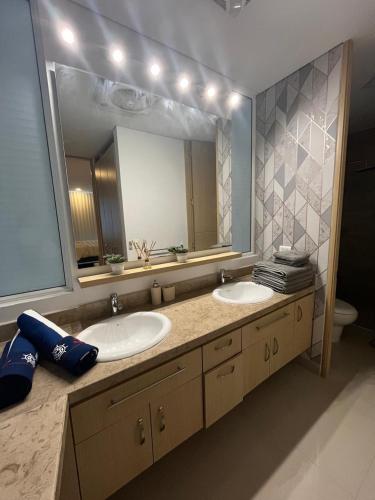 a bathroom with two sinks and a large mirror at Reserva Del Mar Apartamentos in Gaira