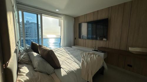 a bedroom with a bed and a large window at Reserva Del Mar Apartamentos in Gaira