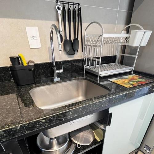 a kitchen counter with a sink and utensils at Capri Residence Luxo 02 quartos by Premium Reservas in Porto De Galinhas