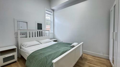 a white bedroom with a bed and a window at Spacious Home Perfect for Two Families or Groups in Langley