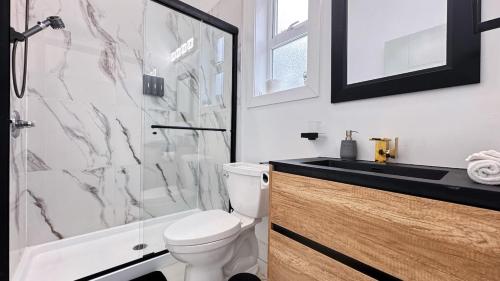 a bathroom with a toilet and a sink and a shower at Spacious Home Perfect for Two Families or Groups in Langley