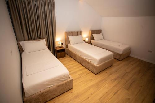 a hotel room with two beds and two lamps at Villa Klaus Center Hotel in Tirana