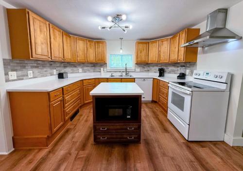a kitchen with wooden cabinets and white appliances at 91M Renovated Bethlehem home with hot tub, firepit, large yard, walk to restaurants in Bethlehem