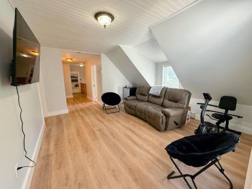 a living room with a couch and a flat screen tv at 91M Renovated Bethlehem home with hot tub, firepit, large yard, walk to restaurants in Bethlehem