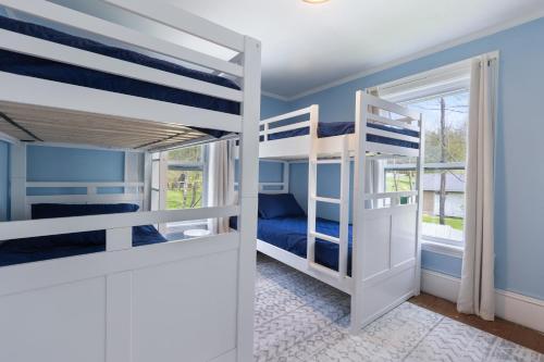 a bedroom with two bunk beds and a window at 7PH Sunny Farmhouse Retreat, AC, Game Room, Dog Friendly in Jefferson