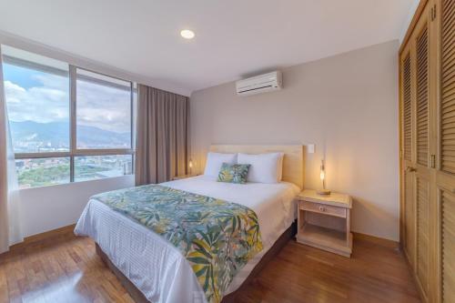 a hotel room with a bed and a large window at Alcazar de Oviedo by EE Hoteles in Medellín