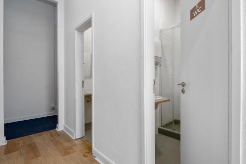 porta aperta per un bagno con specchio di Plaza Inn Hostel & Rooms a Faro