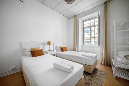 due letti in una stanza bianca con una finestra di Plaza Inn Hostel & Rooms a Faro