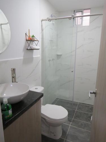 a bathroom with a toilet and a glass shower at Acogedor apto in Sabaneta