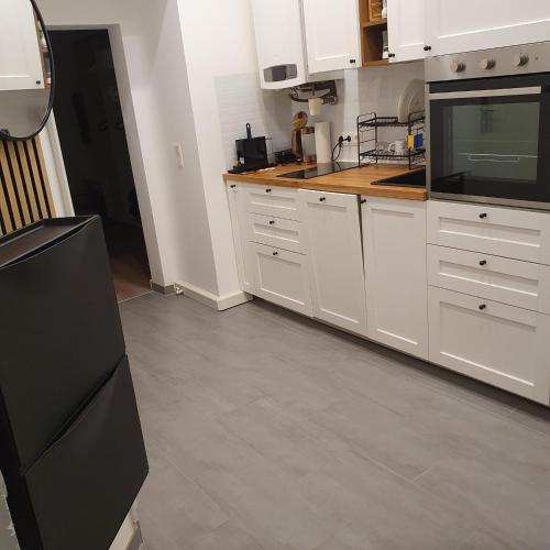 a kitchen with white cabinets and a black refrigerator at City 1100 in Vienna