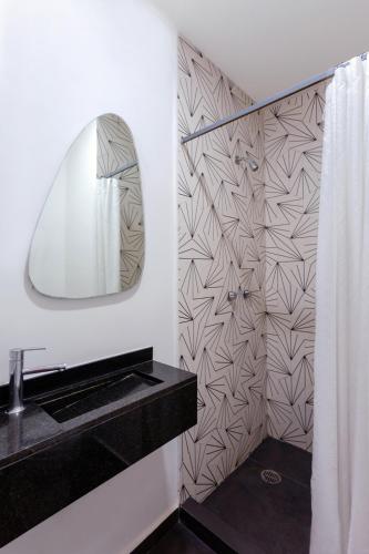 a bathroom with a black sink and a mirror at Suites Alcazar in Mexico City