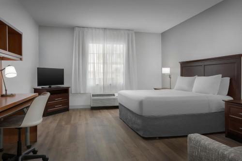 a bedroom with a bed and a desk and a television at TownePlace Suites El Centro in El Centro