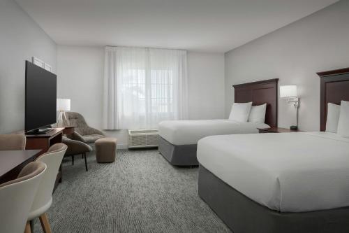 a hotel room with two beds and a television at TownePlace Suites El Centro in El Centro