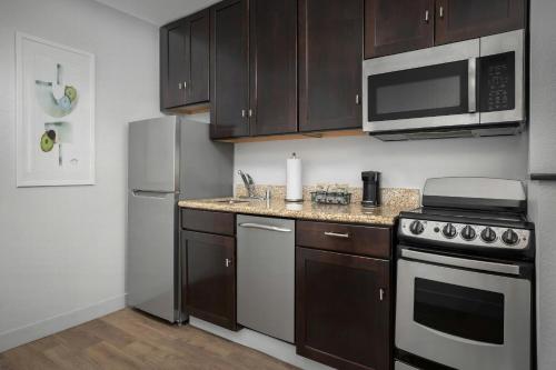 a kitchen with stainless steel appliances and wooden cabinets at TownePlace Suites El Centro in El Centro