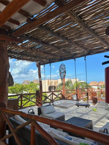 a porch with a swinging bed and a view of the desert at Ensueño Holbox & Beach Club in Holbox Island