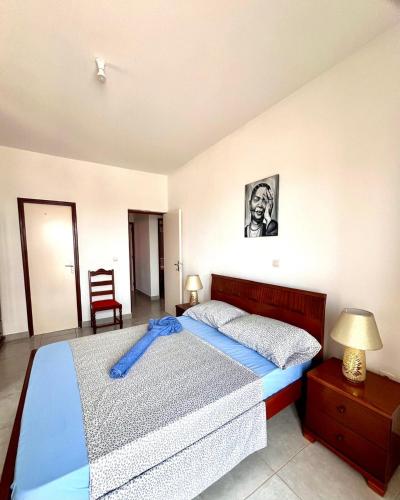 a bedroom with a bed with a blue blanket on it at Casa BB&Djassi - Apartment T3 in Ponta do Sol
