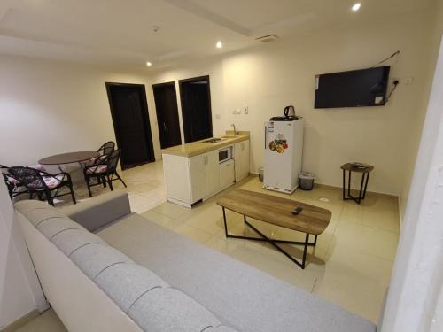 a living room with a couch and a table and a tv at شقق جديل للشقق المخدومة in Taif