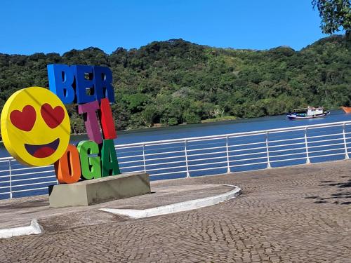 a sign that says be happy next to a river at Suítes Para Casal in Bertioga