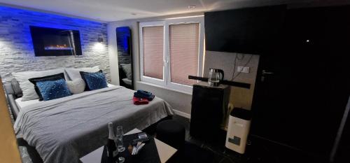 Un dormitorio con una cama con luces azules. en Jacuzzi przy Plaży - Apartament Kołobrzeg, en Kołobrzeg