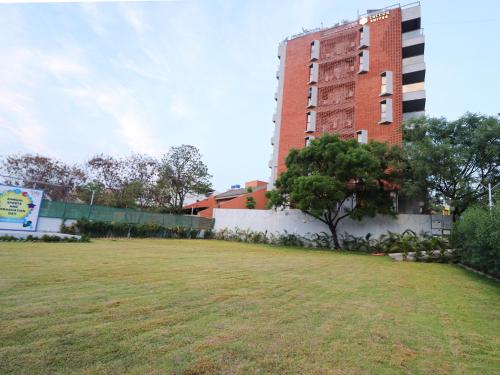 a grassy field in front of a tall building at Hotel Tattva Suites in Pune
