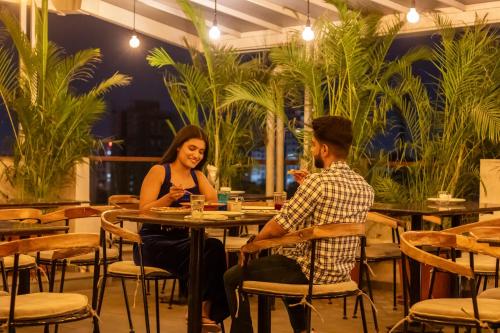 a man and a woman sitting at a table in a restaurant at Hotel Tattva Suites in Pune