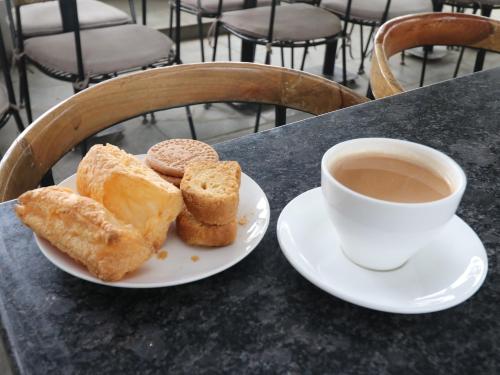 a plate of pastries and a cup of coffee on a table at Hotel Tattva Suites in Pune