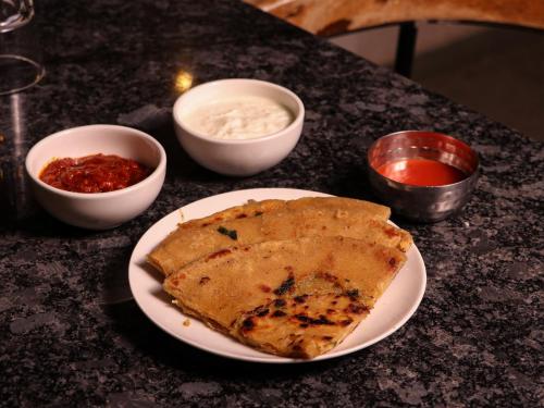 a plate with a piece of food on a table at Hotel Tattva Suites in Pune