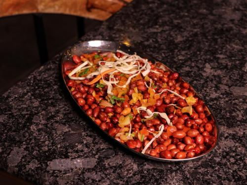 a tray of food on a counter with a bowl of fruit at Hotel Tattva Suites in Pune