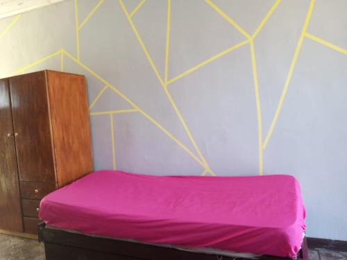 ein Schlafzimmer mit einem lila Bett und einer Wand in der Unterkunft CABAÑITAS del sur in Mar del Plata