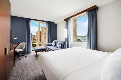 a hotel room with a bed and a desk and window at Courtyard New York Manhattan/Upper East Side in New York