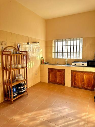 a kitchen with wooden cabinets and a tiled floor at Private Room With Balcony, External Bathroom in Cotonou