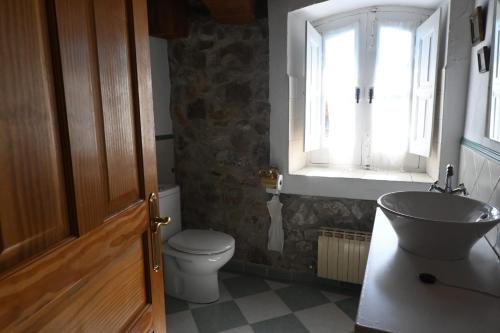 a bathroom with a toilet and a sink and a window at La casa del agua Cantabria in Ampuero