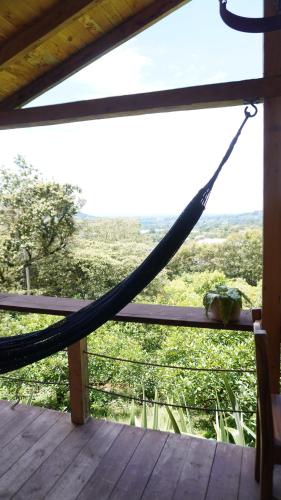 a hammock on a porch with a view at Cabaña entre los árboles del bosque de Efímero la Ceja in La Ceja