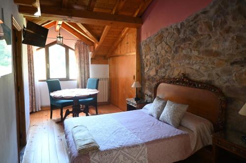 a bedroom with a bed and a table with chairs at La casa del agua Cantabria in Ampuero