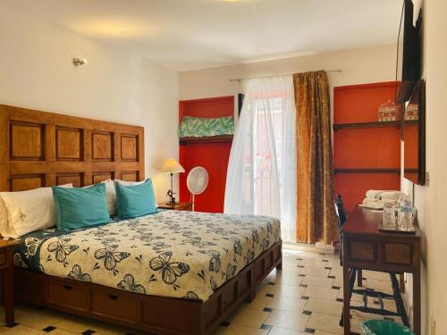 a bedroom with a bed and a desk and a window at Hotel Doña Chela En Calvillo in Calvillo