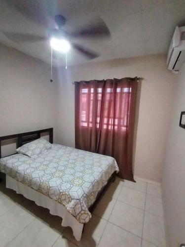 a bedroom with a bed and a red window at Hermosa casa entre David y Boquete in Los Algarrobos