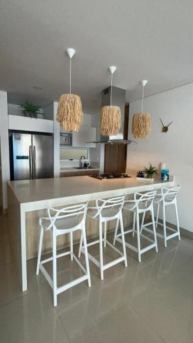 a kitchen with a counter and stools in a room at Reserva Del Mar Apartamentos in Gaira