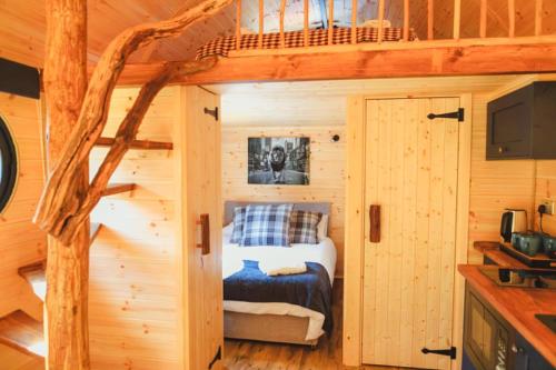 ein Schlafzimmer in einem Blockhaus mit einem Bett in der Unterkunft Butterfly Lodge in Headcorn
